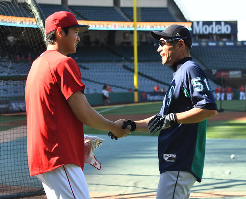エンゼルス対マリナーズ 試合前の練習中にイチロー(右)に笑顔で握手をするエンゼルス大谷(撮影・菅敏)