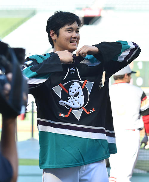 NHLアナハイムダックスから贈られたユニホームに笑顔で袖を通すエンゼルス大谷(撮影・菅敏)