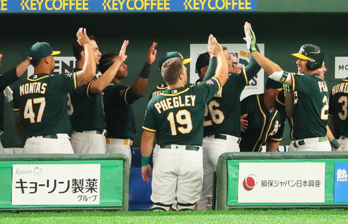 日本ハム対アスレチックス 2回表アスレチックス無死、ピスコティ(右端)は左越え本塁打を放ちナインとタッチを交わす(撮影・足立雅史)