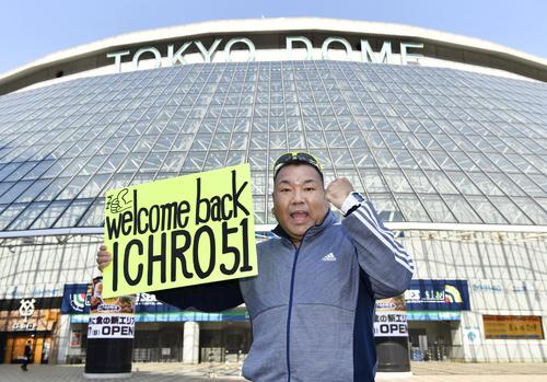米大リーグ開幕戦観戦のため応援のボードを持ち、東京ドームを訪れた人(共同)