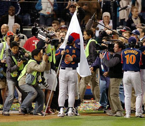 06年3月、初優勝を決めたセレモニーで、日の丸の旗を持って整列するイチローはそのまま王貞治監督と抱擁し、旗にくるまれる