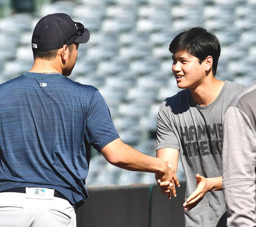 試合前、マリナーズ菊池（左）と再会し、握手であいさつをするエンゼルス大谷（撮影・菅敏）