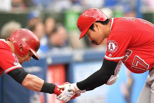 ブルージェイズ対エンゼルス　2回表エンゼルス2死二、三塁、左越えに9号3点本塁打を放ち、カルフーン（左）に握手で迎えられるエンゼルス大谷（撮影・菅敏）