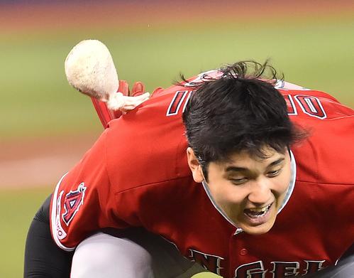 ブルージェイズに勝利し、ナインとハイタッチをするエンゼルス大谷は、飛んできたロージンを慌てて避ける（撮影・菅敏）