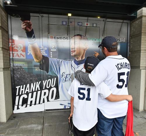 イチロー氏の引退セレモニーで球場の外壁に飾られたパネルを見つめる親子（撮影・菅敏）