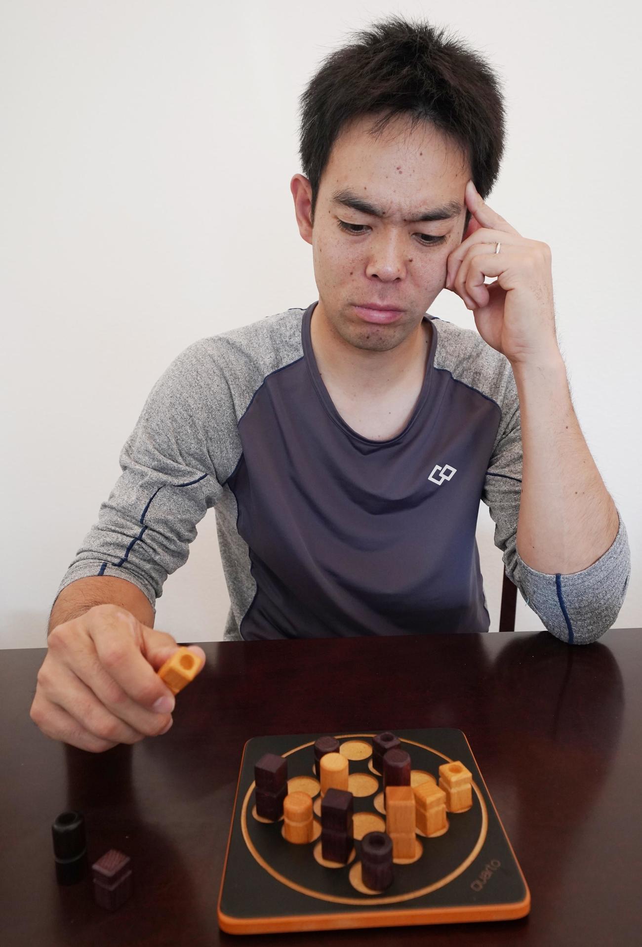 ボードゲームのクアルトをプレーするレッズ秋山。慎重に一手一手を打ち込む（本人提供）
