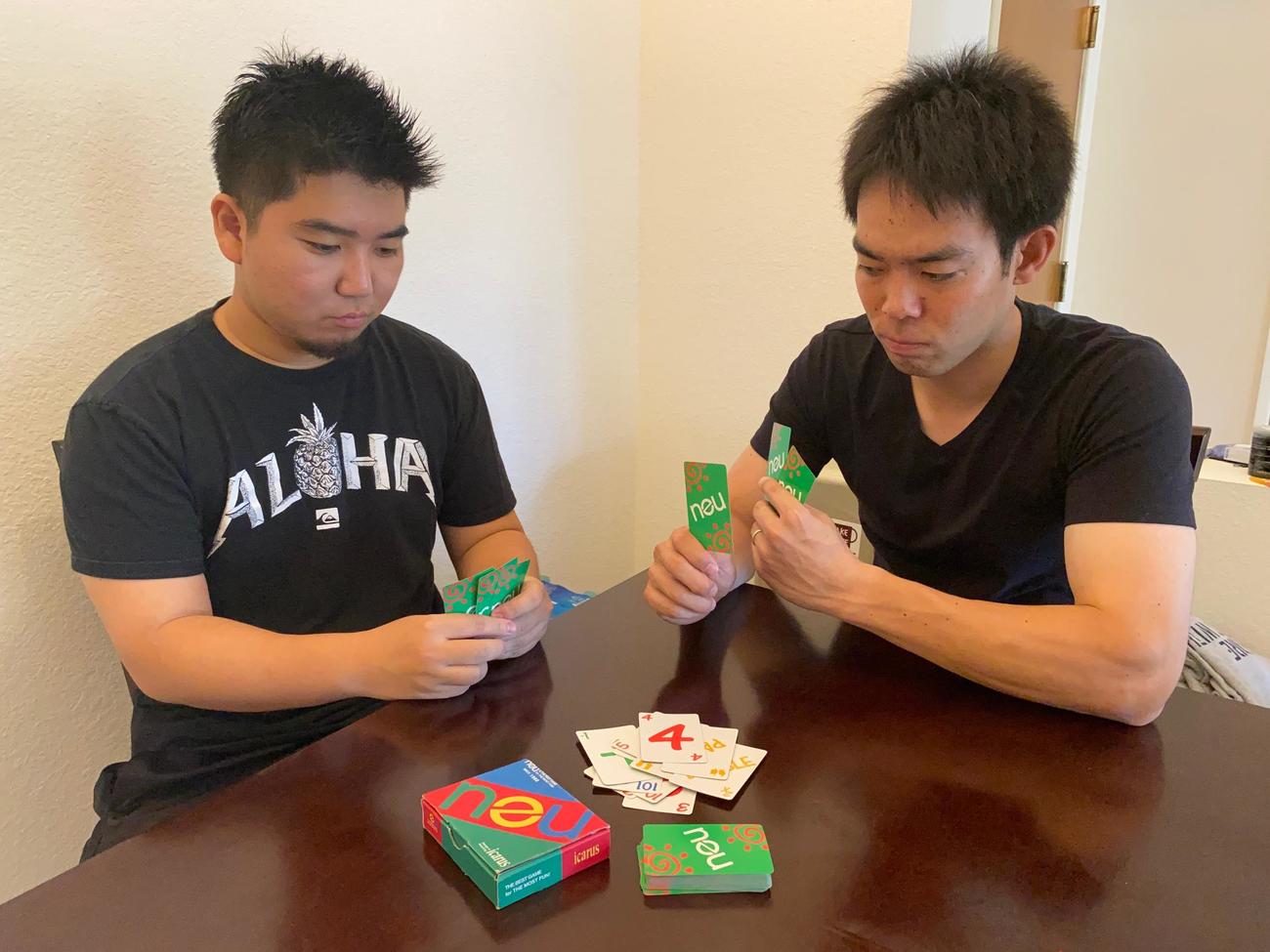 カードゲームのノイで対戦するレッズ秋山とルーク篠田通訳（本人提供）