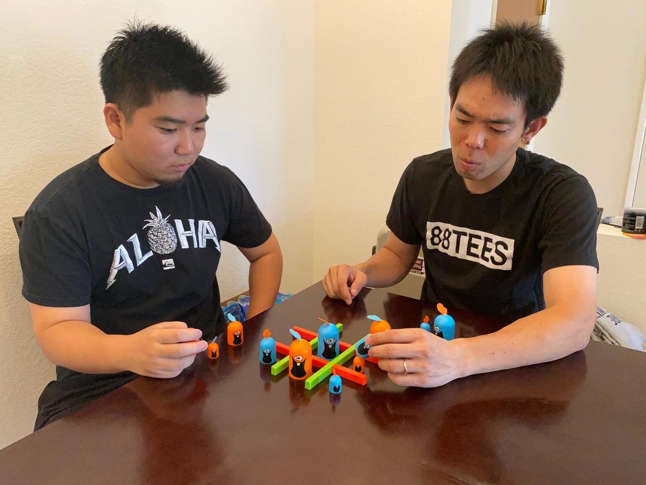 ボードゲーム・ゴブレットゴブラーズで対戦するレッズ秋山とルーク篠田通訳（本人提供）