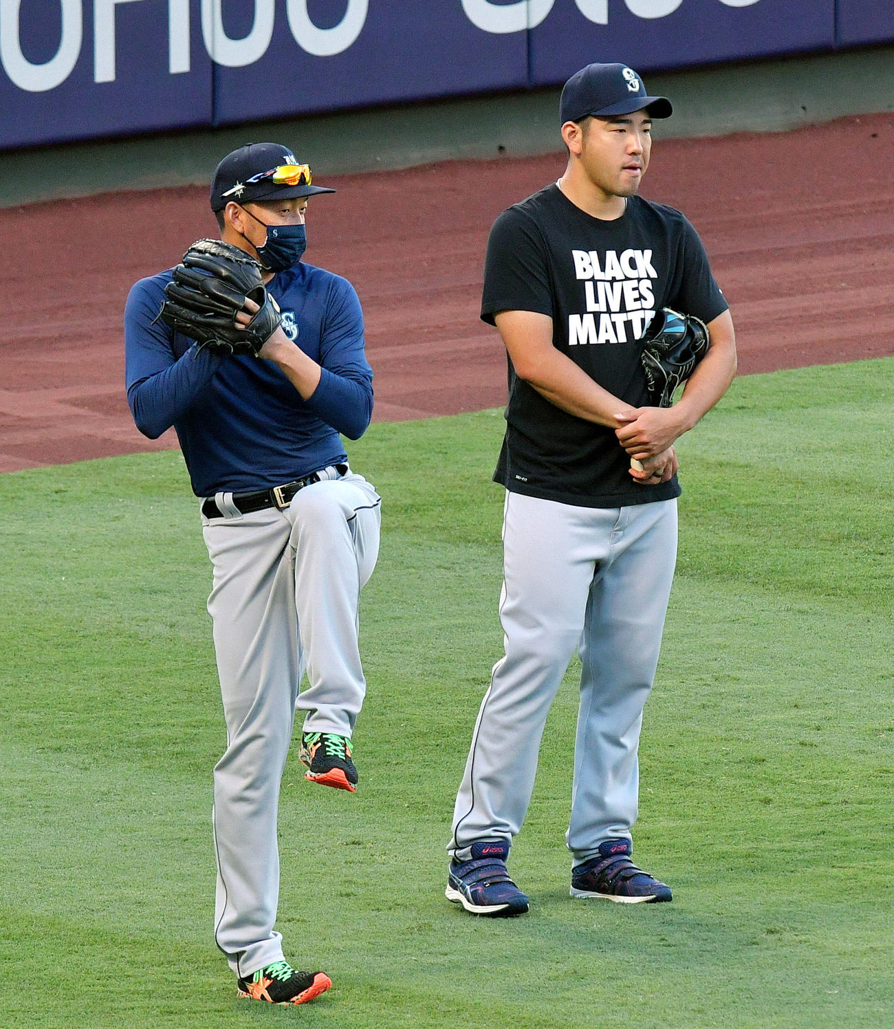 試合前の練習で話すマリナーズの平野（左）と菊池（共同）