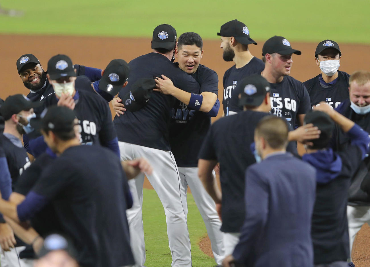 ヤンキースを破ってリーグ優勝決定シリーズ進出を決め、チームメートと抱き合って喜ぶレイズ筒香（中央）（共同）