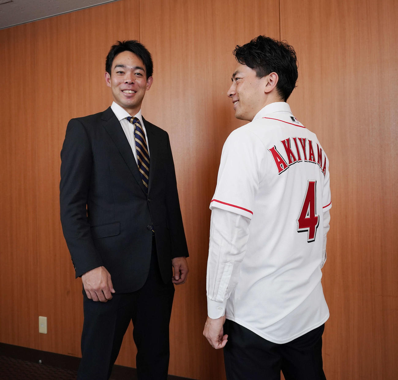シンシナティ・レッズ秋山のユニホームに袖を通し笑顔の小泉進次郎環境相（右）と秋山（撮影・菅敏）