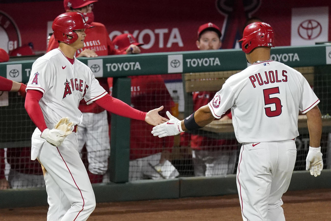 8回、勝ち越しのホームを踏んだ大谷（左）は三ゴロを放ったプホルスとタッチ（AP）