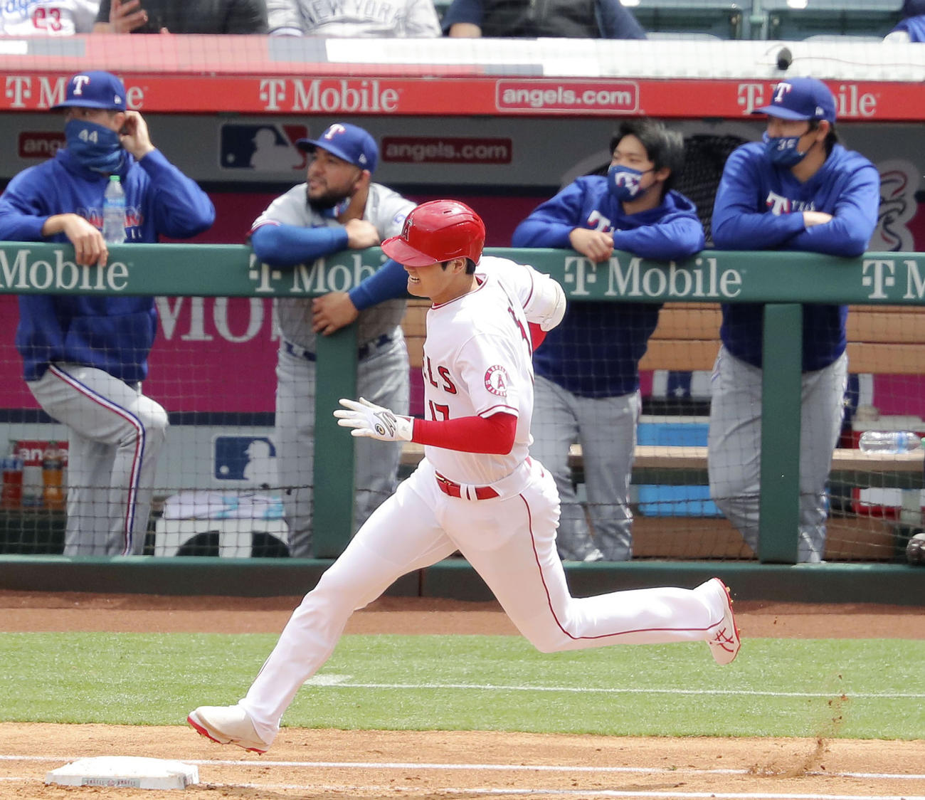 3回に5号ソロを放って塁を回るエンゼルス・大谷と、打球の行方を見つめるレンジャーズベンチ。右端は有原（共同）