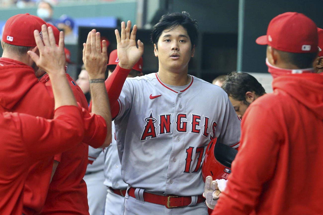 1回、先制の生還を果たしナインとタッチする大谷（AP）