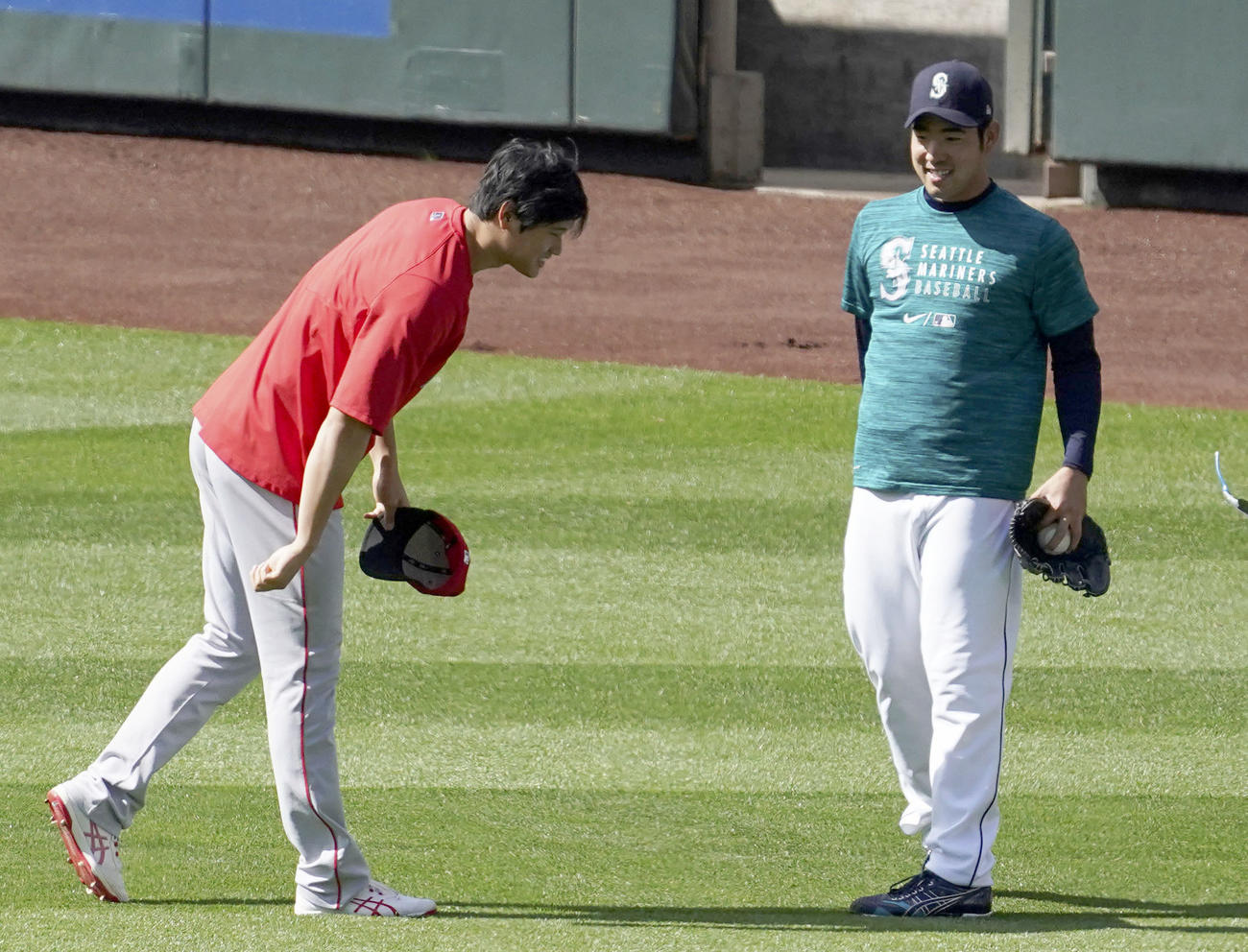 試合前の練習の合間に、マリナーズ菊池（右）にあいさつするエンゼルス大谷（共同）