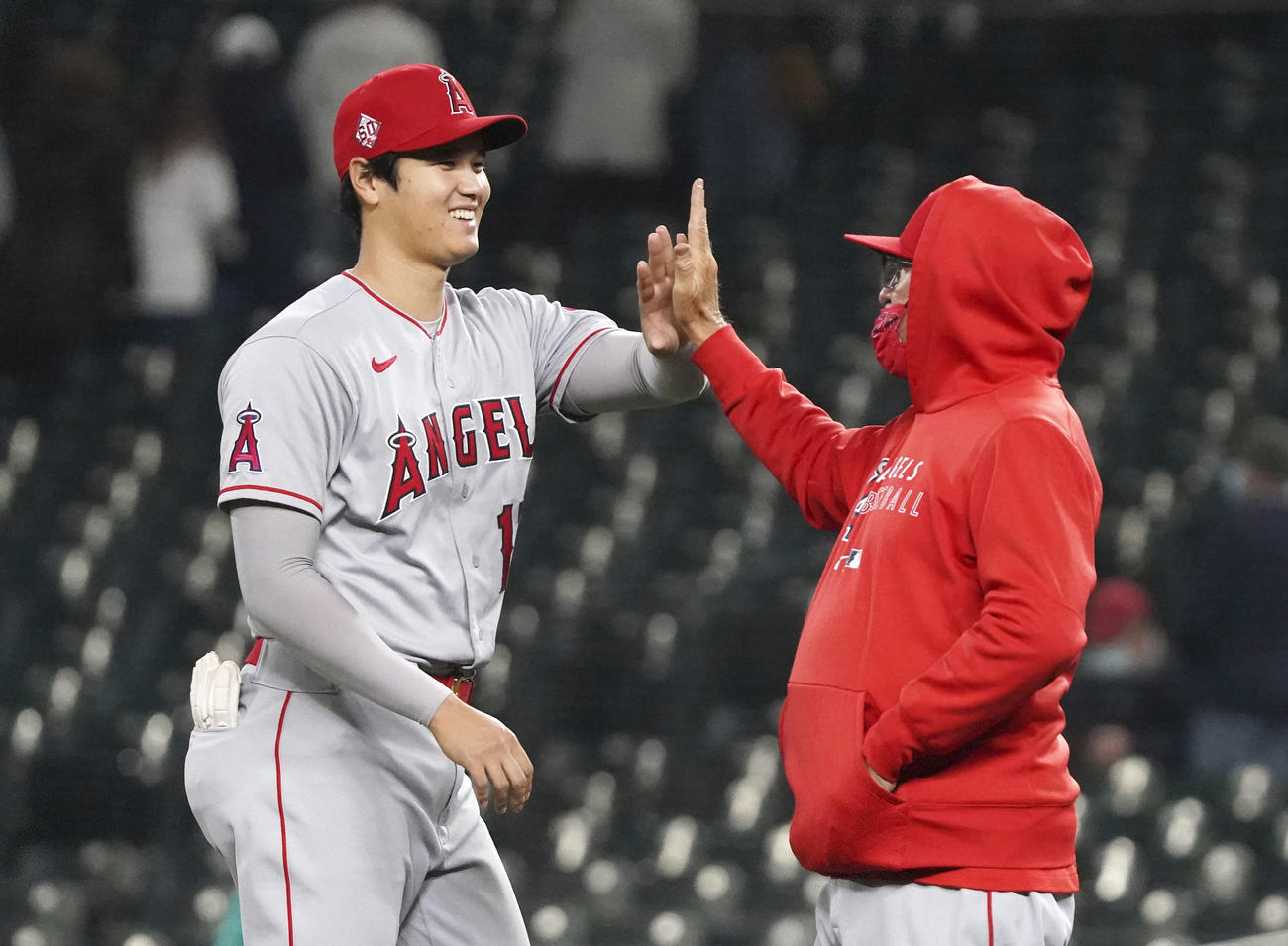 マリナーズに勝利し、マドン監督（右）とタッチを交わすエンゼルス大谷（共同）
