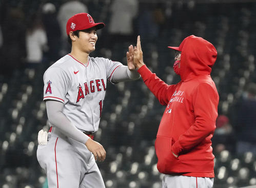マリナーズに勝利し、マドン監督（右）とタッチを交わすエンゼルス大谷（共同）
