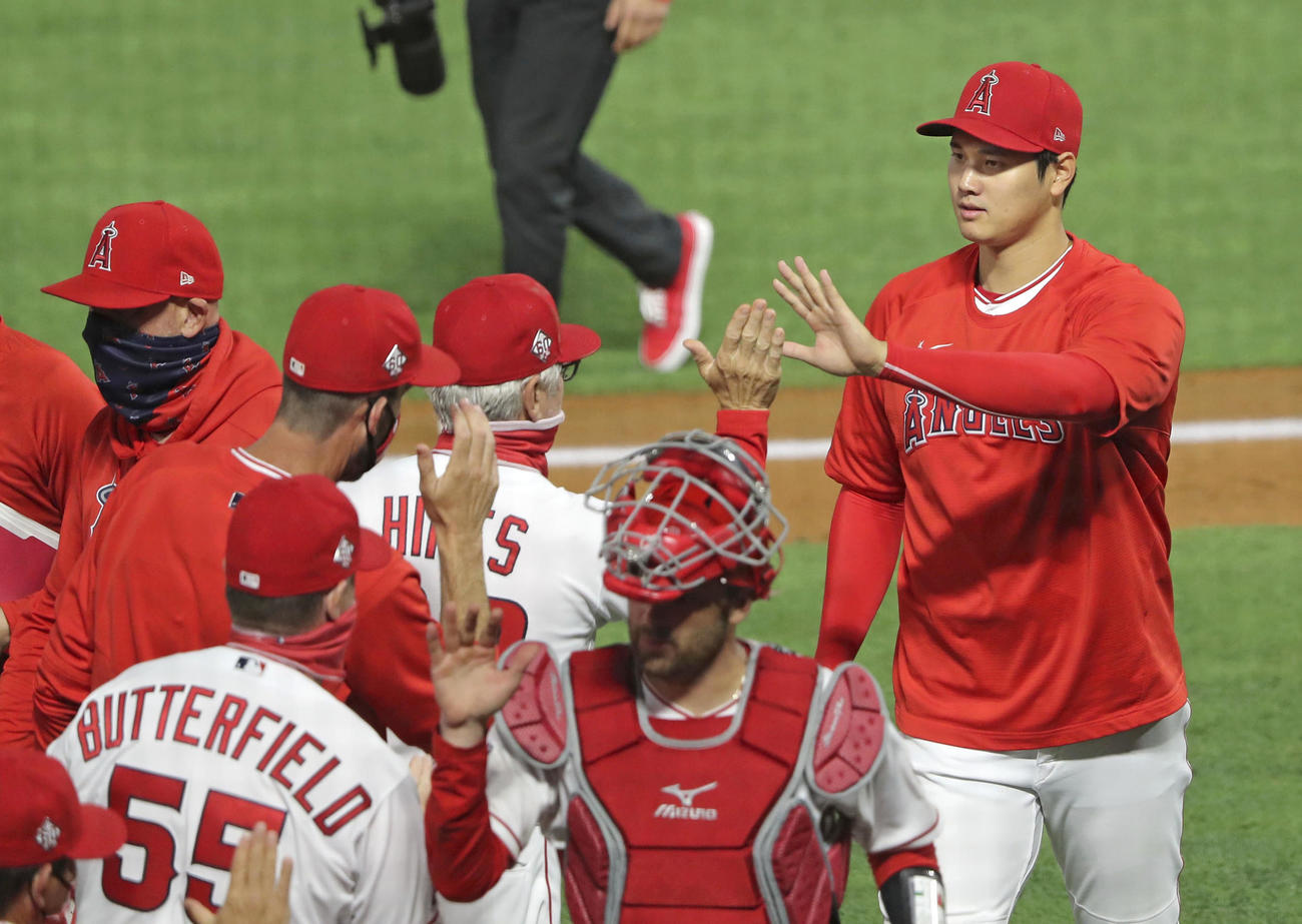 ドジャースに勝利し、チームメートとタッチを交わすエンゼルス大谷（右端）（共同）