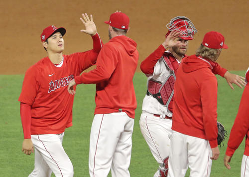 ドジャースに勝利し、チームメートとタッチを交わすエンゼルス大谷(左端)(共同)