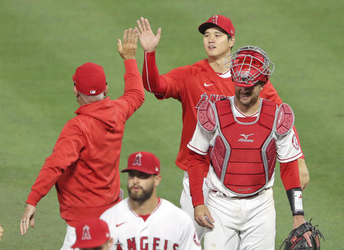 ドジャースに勝利し、マドン監督(左)とタッチを交わすエンゼルス大谷(共同)