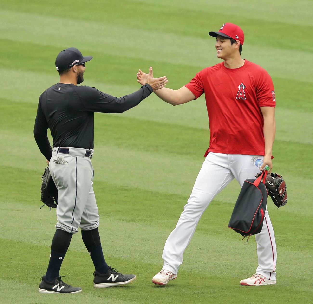 試合前、元同僚のインディアンスのリベラ（左）とあいさつするエンゼルス・大谷（共同）