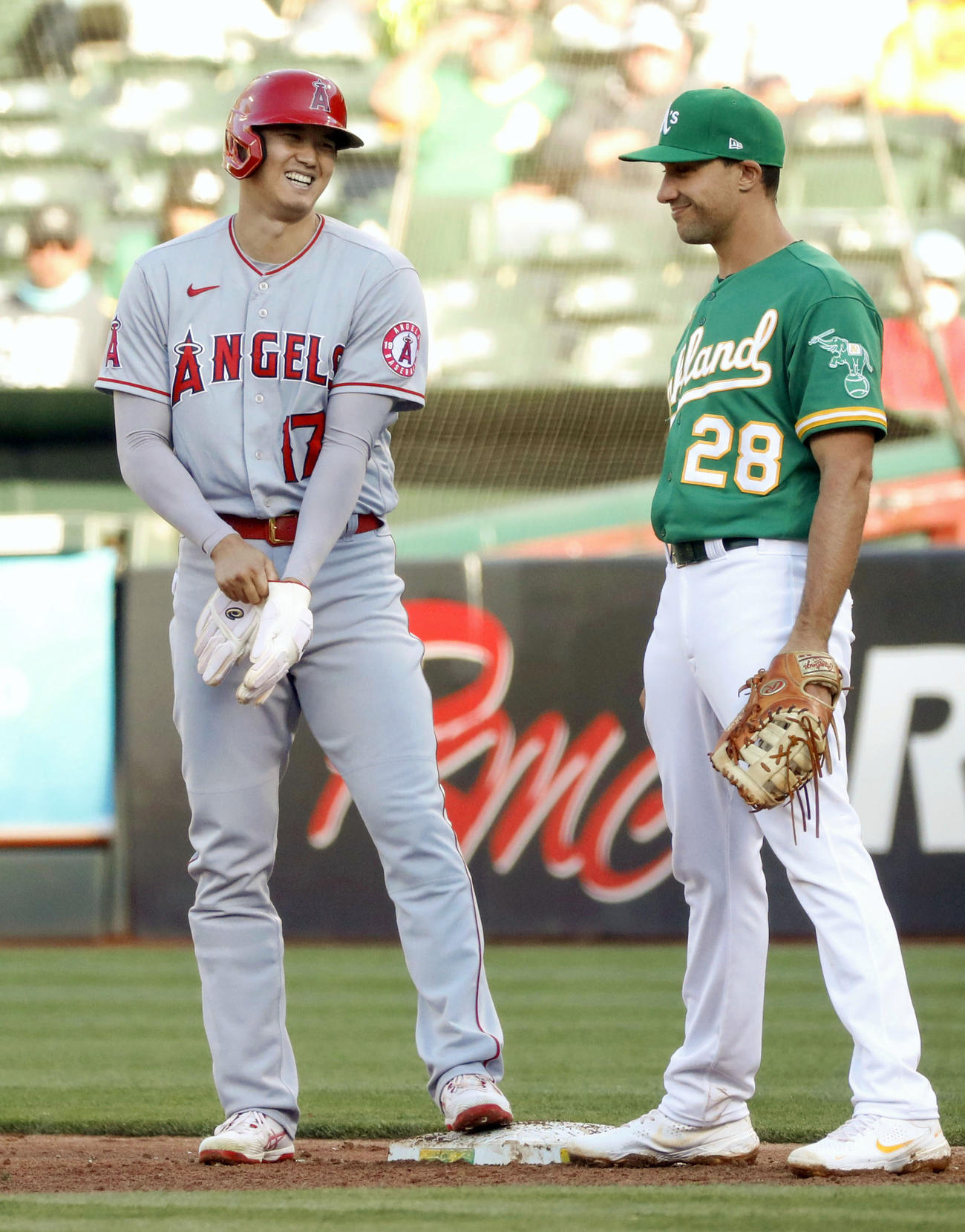 アスレチックス戦の2回、安打を放って一塁手オルソン（右）と談笑するエンゼルス大谷（共同）
