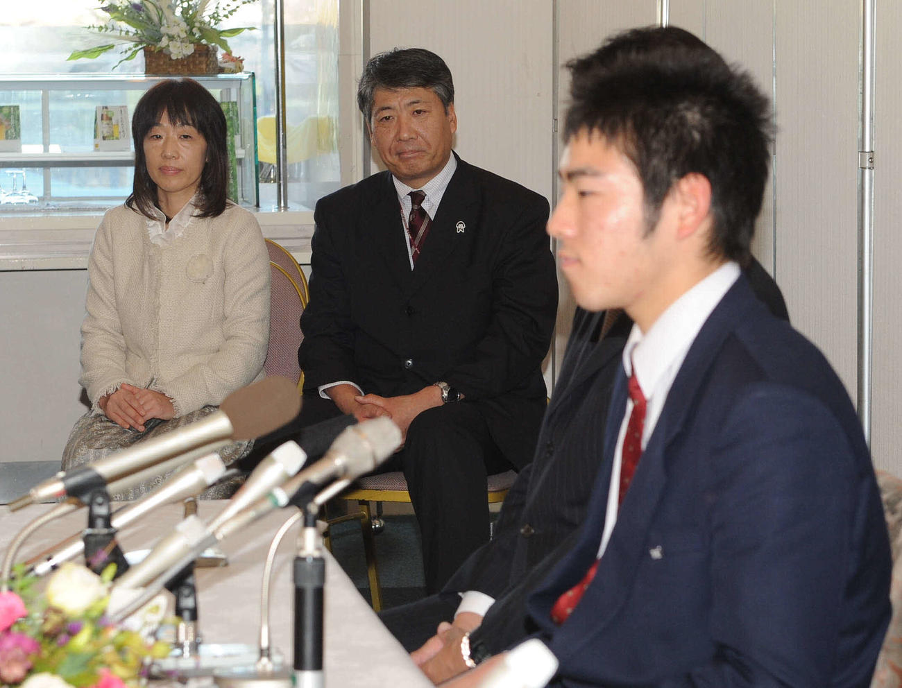 09年11月、西武との仮契約を済ませ会見する菊池雄星を見守る、母加寿子さんと父雄治さん