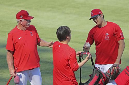 試合前にコーチ(左)と話すエンゼルス大谷(共同)