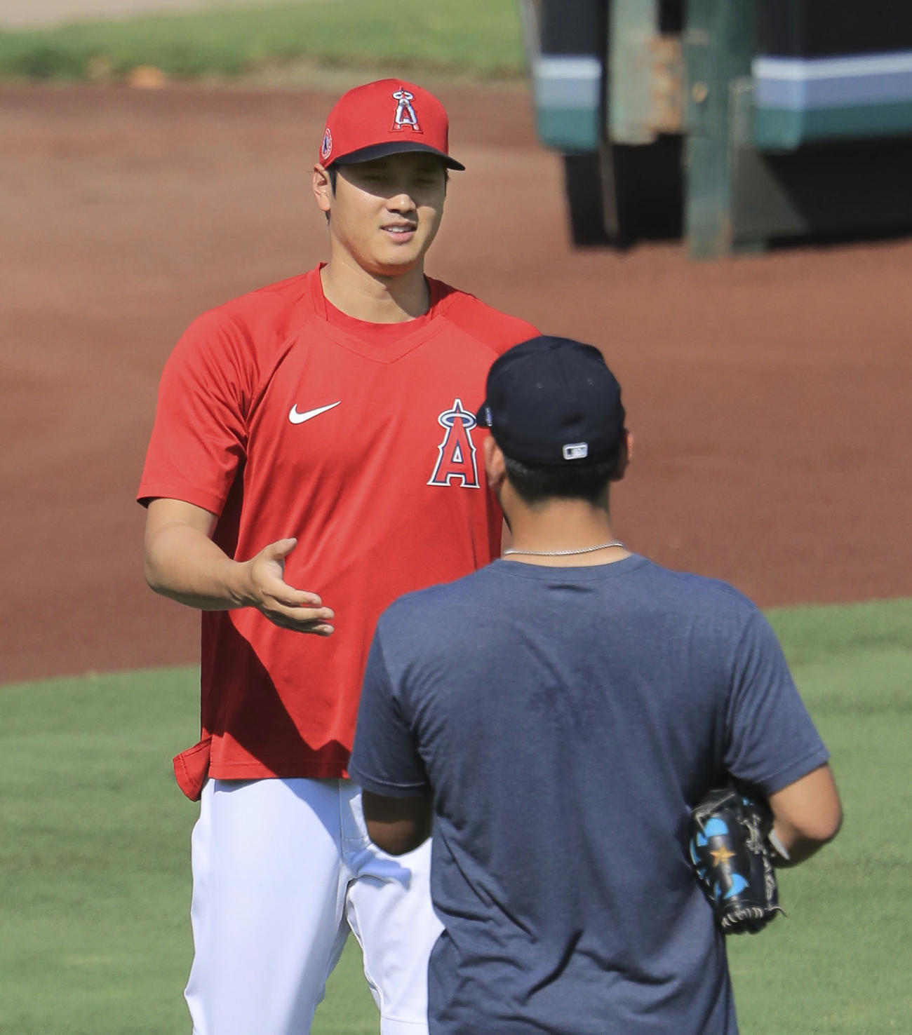 試合前の練習中、マリナーズ・菊池（手前）とあいさつを交わすエンゼルス・大谷＝アナハイム（共同）