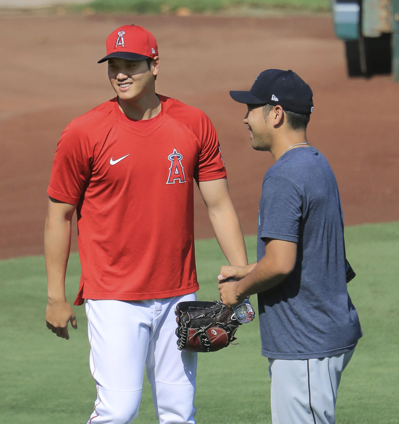 試合前の練習中、マリナーズ・菊池（手前）とあいさつを交わすエンゼルス・大谷＝アナハイム（共同）