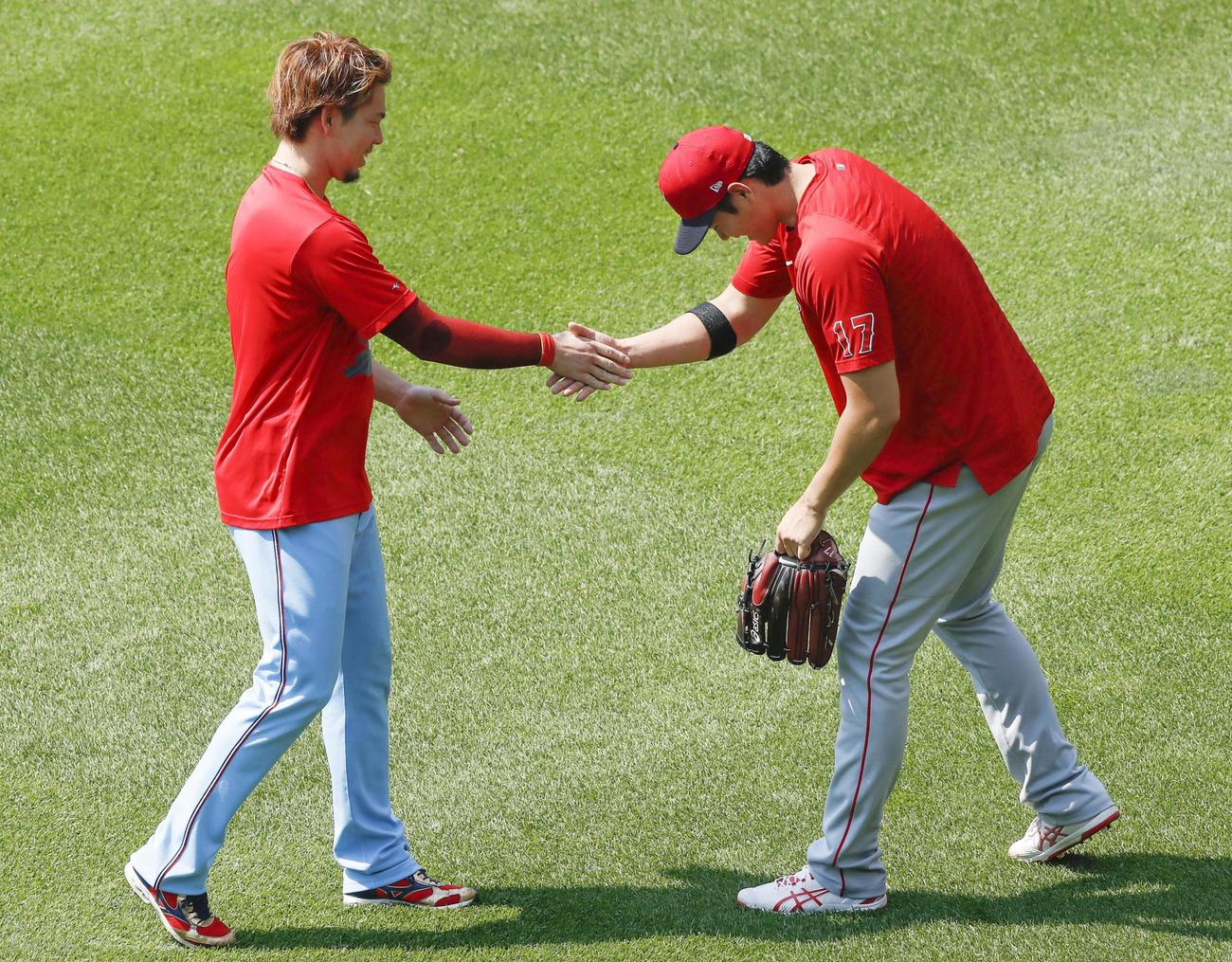 試合前、ツインズ前田（左）と握手するエンゼルス大谷（共同）
