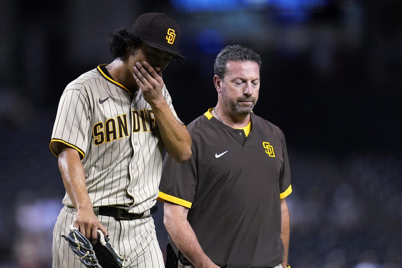 トレーナーとともにベンチへ下がるダルビッシュ（AP）