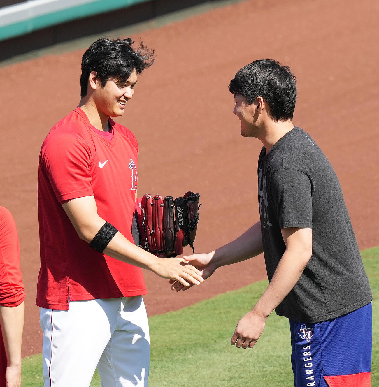 エンゼルス対レンジャーズ　試合前、レンジャーズ有原（右）に握手であいさつするエンゼルス大谷（撮影・菅敏）