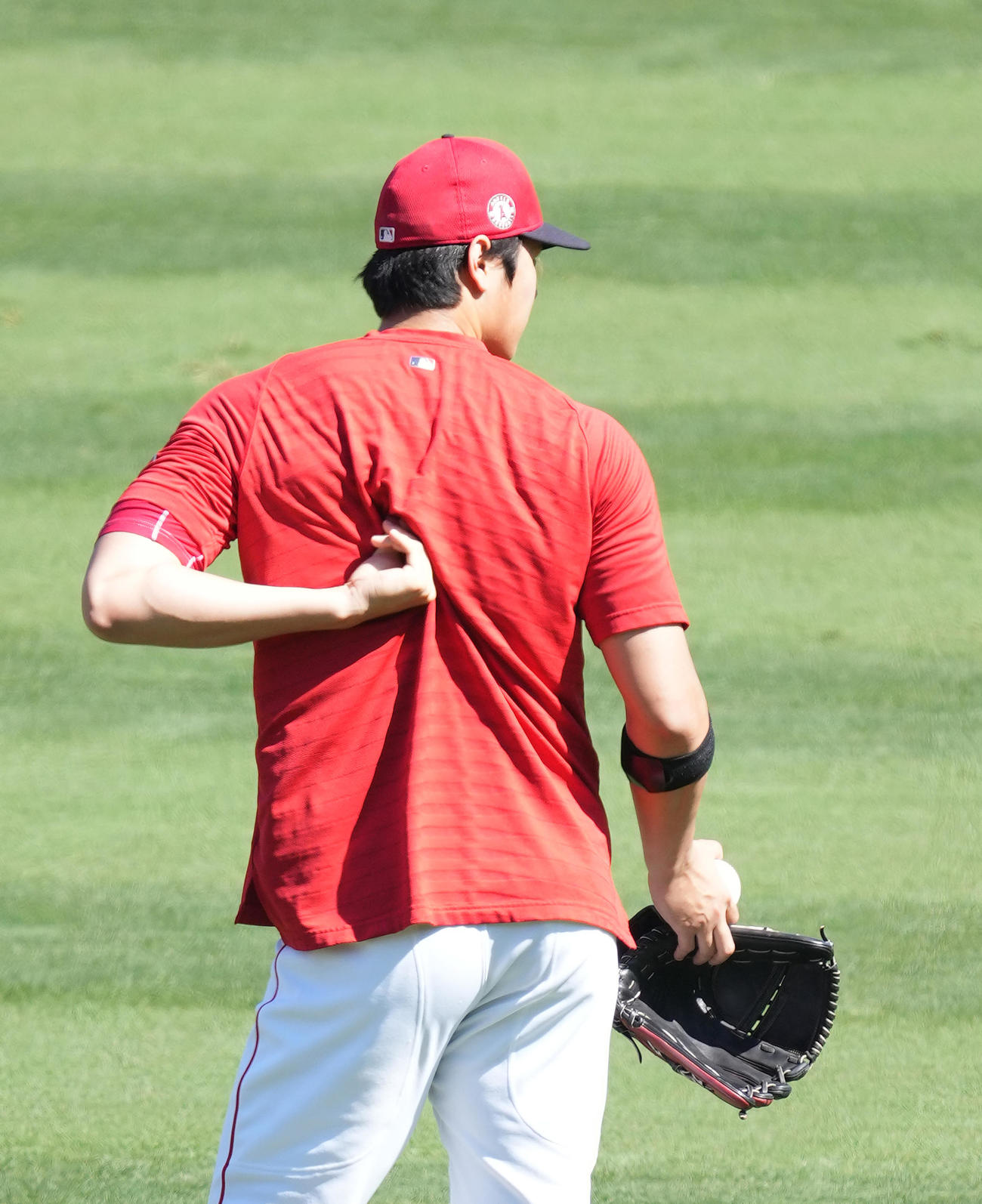 エンゼルス対アスレチックス　試合前、キャッチボールで調整するエンゼルス大谷は、投球の合間に背中を押させる（撮影・菅敏）