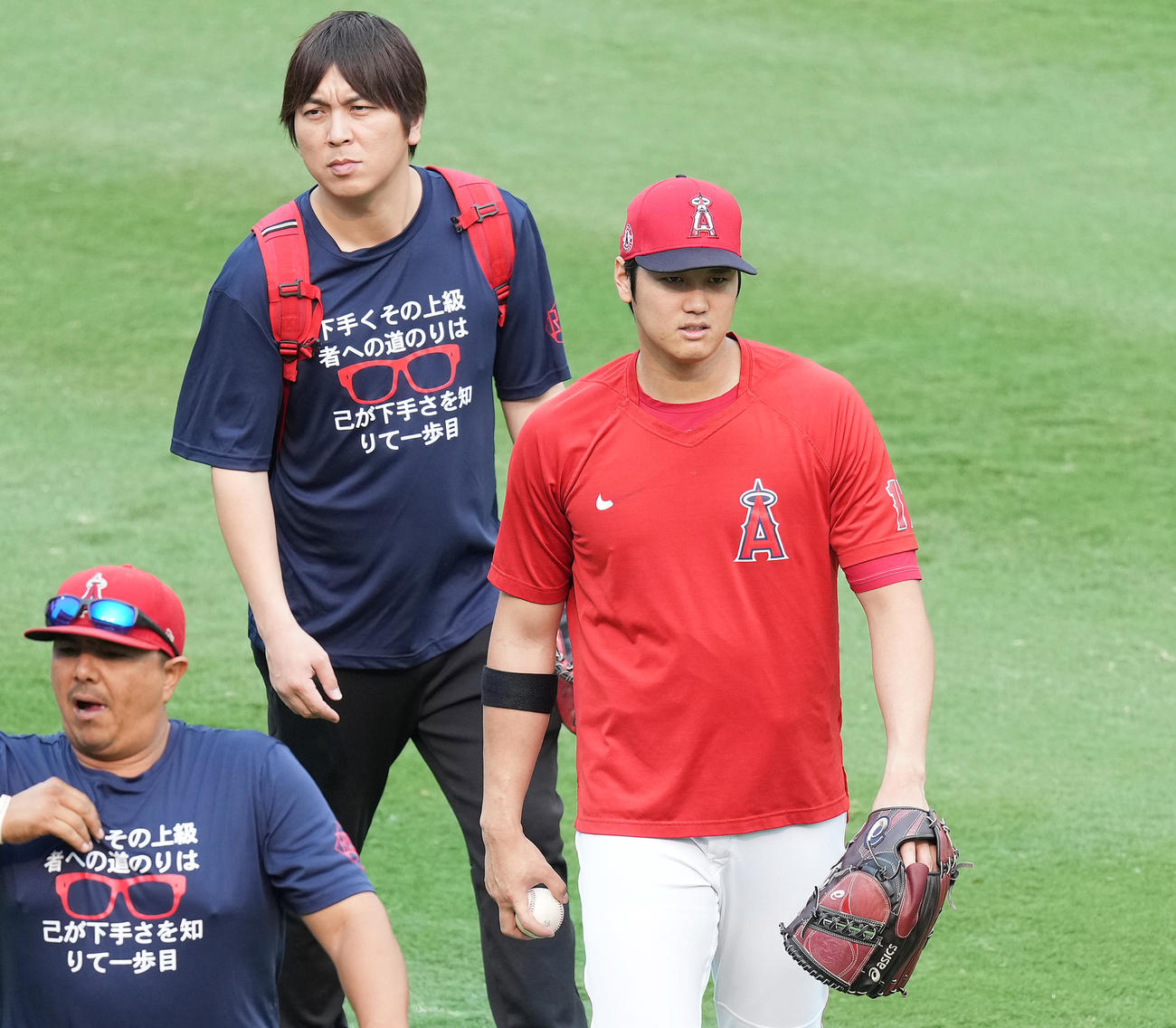 エンゼルス対アストロズ　試合前の練習を終え、日本語でメッセージがプリントされたTシャツを着た水原通訳（中央）と引き揚げるエンゼルス大谷（撮影・菅敏）