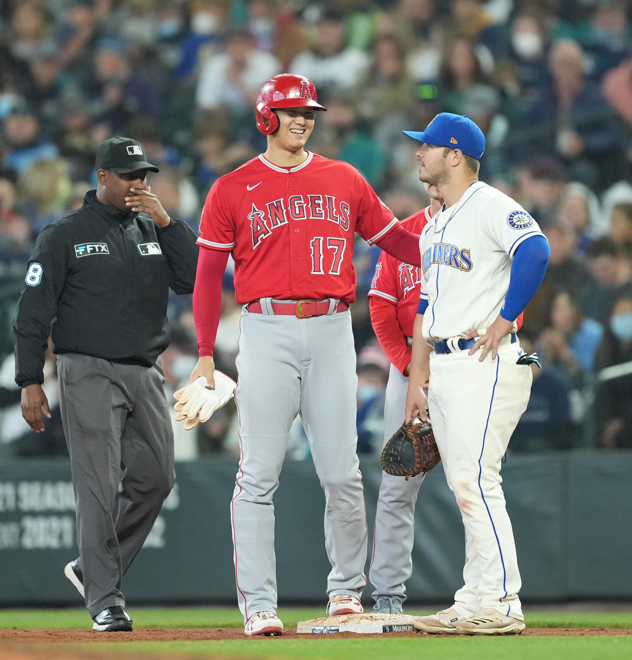 マリナーズ対エンゼルス　5回表エンゼルス2死三塁、申告敬遠を受けるも、マリナーズ・フランス（右）と笑顔で話すエンゼルス大谷（撮影・菅敏）