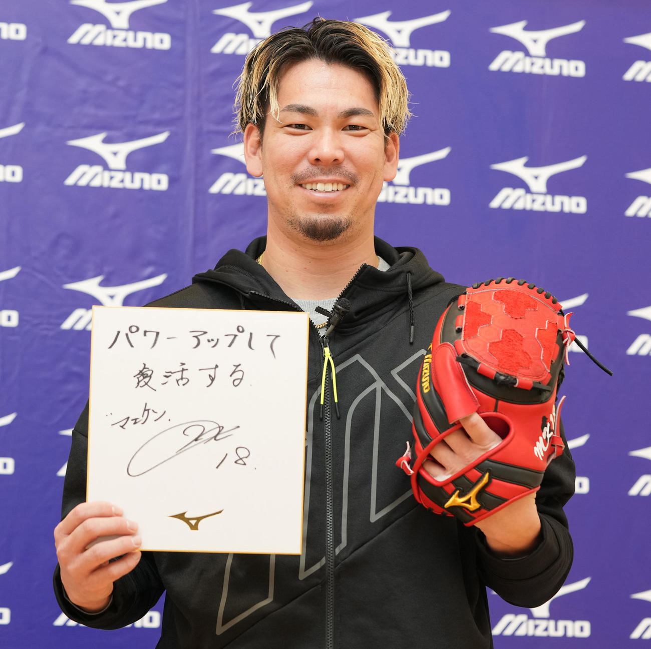 今季使用するミズノのグラブをはめ、色紙を手に写真に納まるツインズ前田（撮影・鈴木みどり）