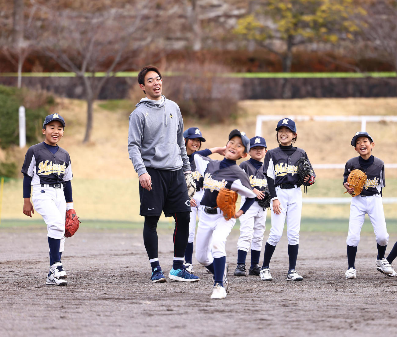 野球教室で子どもたちと楽しそうに笑顔を見せるレッズ秋山（左から2人目）（撮影・垰建太）