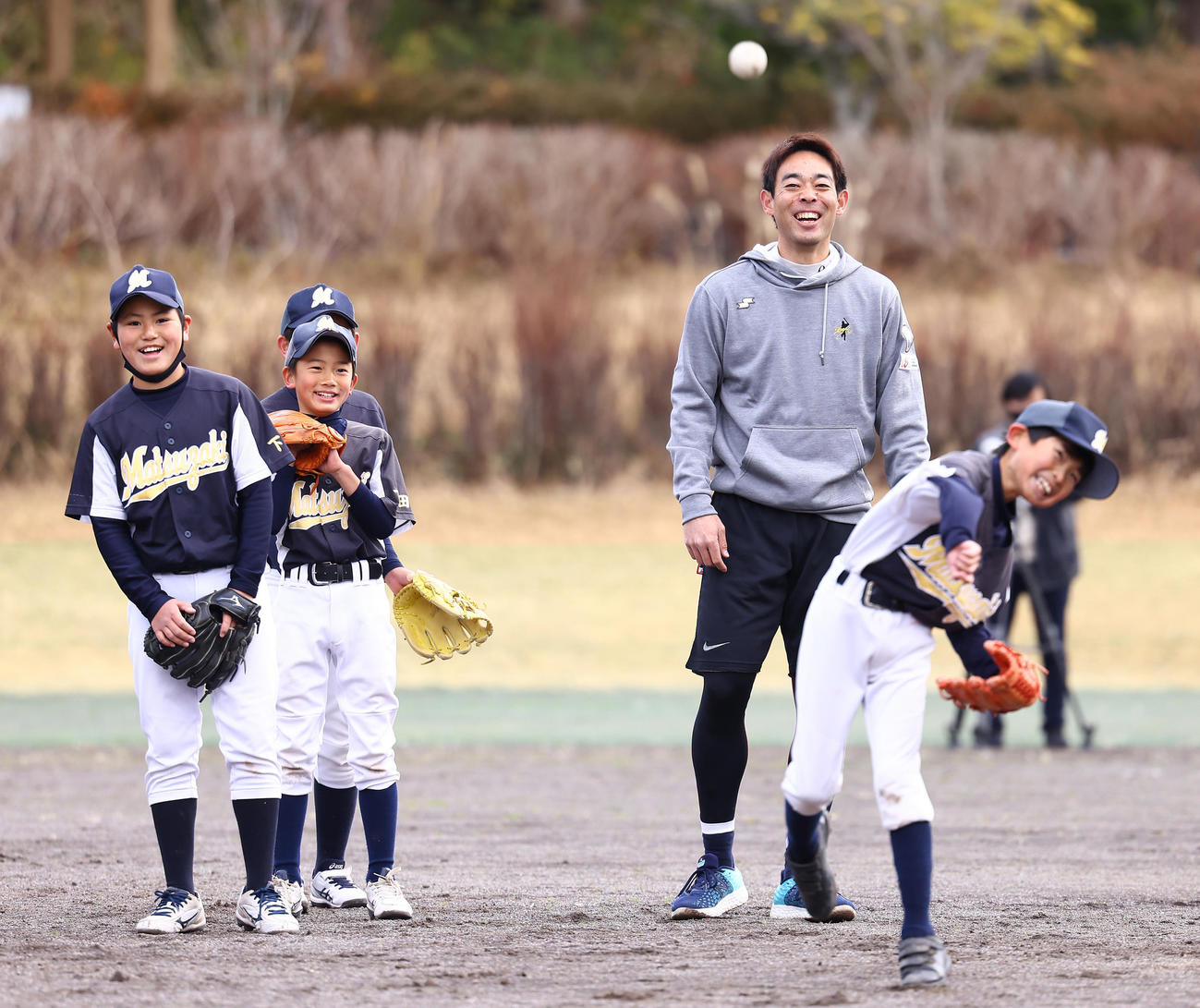 野球教室で子どもたちと楽しそうに笑顔を見せるレッズ秋山（中央）（撮影・垰建太）