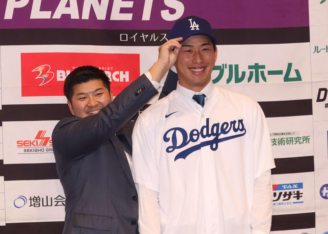 BC・茨城の色川冬馬GMにドジャースの帽子をかぶせてもらう松田康甫投手（撮影・阿部泰斉）