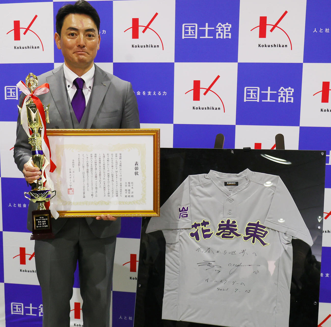 マリナーズ菊池、エンゼルス大谷とともに日本スポーツ学会大賞を受賞した花巻東・佐々木監督は、昨年のMLBオールスター出場時の2人のサインが入ったユニホームと記念撮影（撮影・野上伸悟）