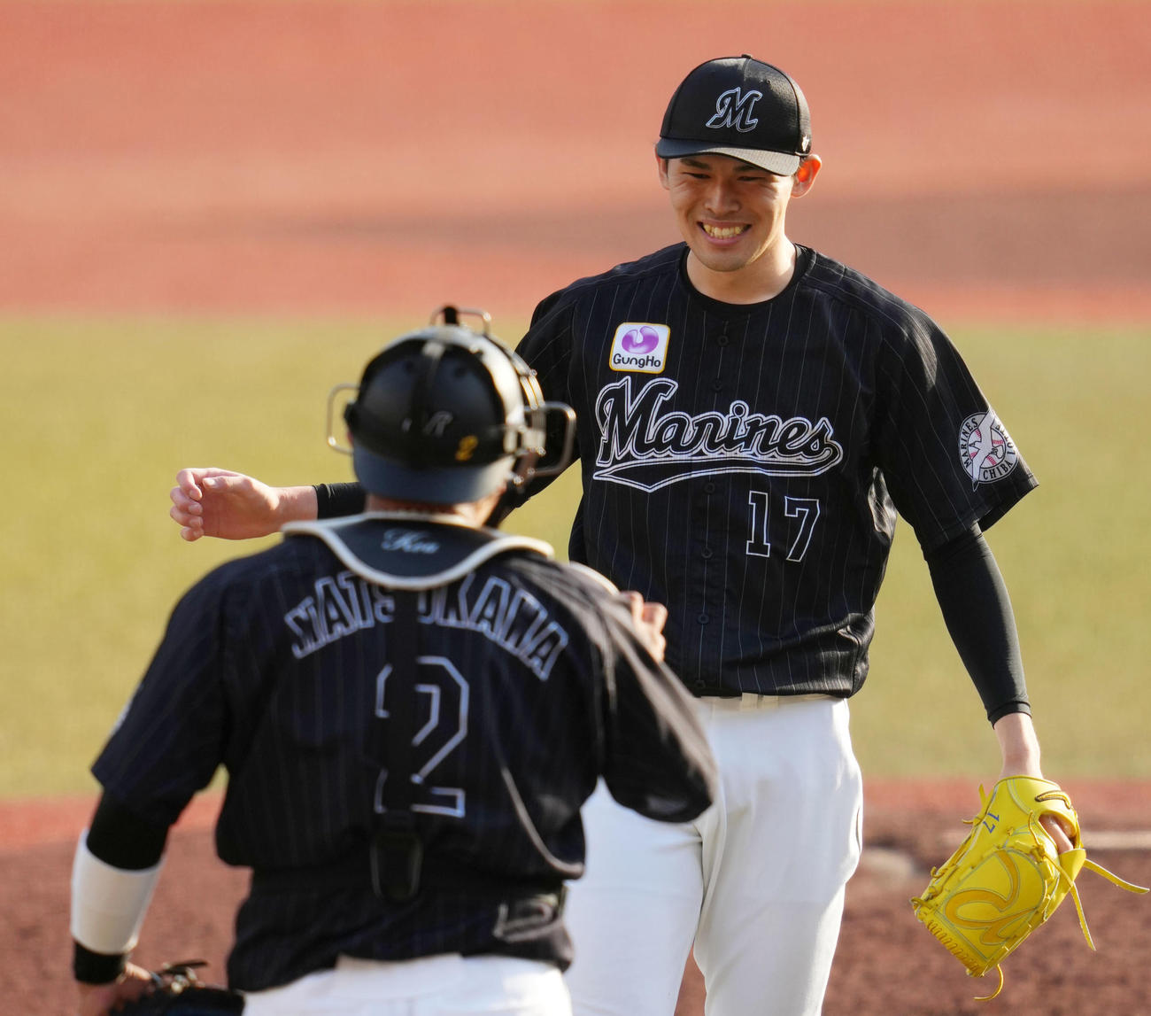 ロッテ対オリックス　完全試合を達成しウイニングボールをロッテ松川（手前）から受け取る佐々木朗（撮影・横山健太）
