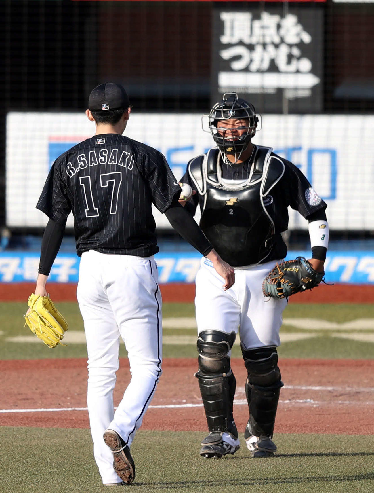 ロッテ対オリックス　9回表オリックス2死、杉本を空振り三振に仕留め、完全試合を達成したロッテ佐々木朗（手前）にウイニングボールを届ける松川（2022年4月10日撮影）