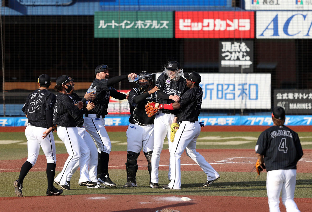 ロッテ対オリックス　完全試合を達成し、レアード（左から3人目）らチームメートから手荒い祝福を受ける佐々木朗（中央）（2022年4月10日撮影）