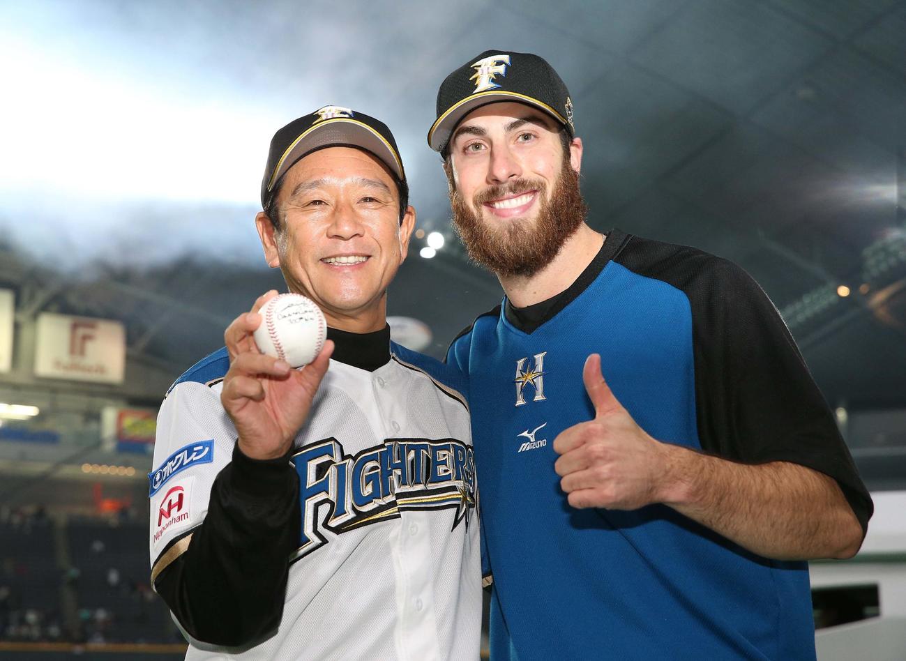 16年4月、監督通算300勝の記念球をアンソニー・バース投手（右）から受け取る栗山監督