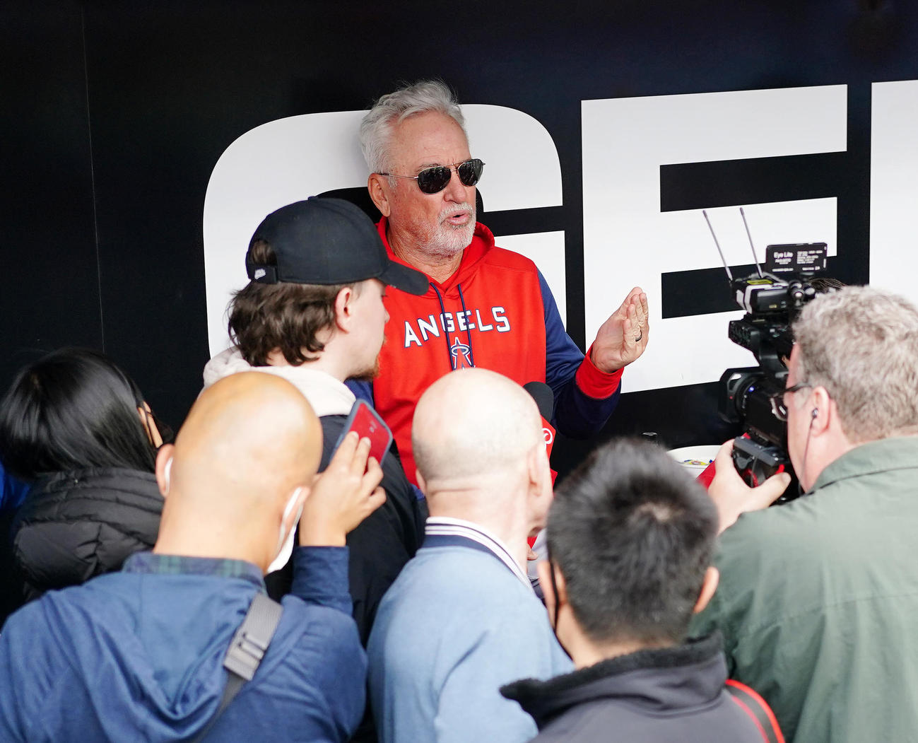 ホワイトソックス対エンゼルス　試合前、ベンチで取材に応じるエンゼルスのマドン監督（後方）（撮影・江口和貴）