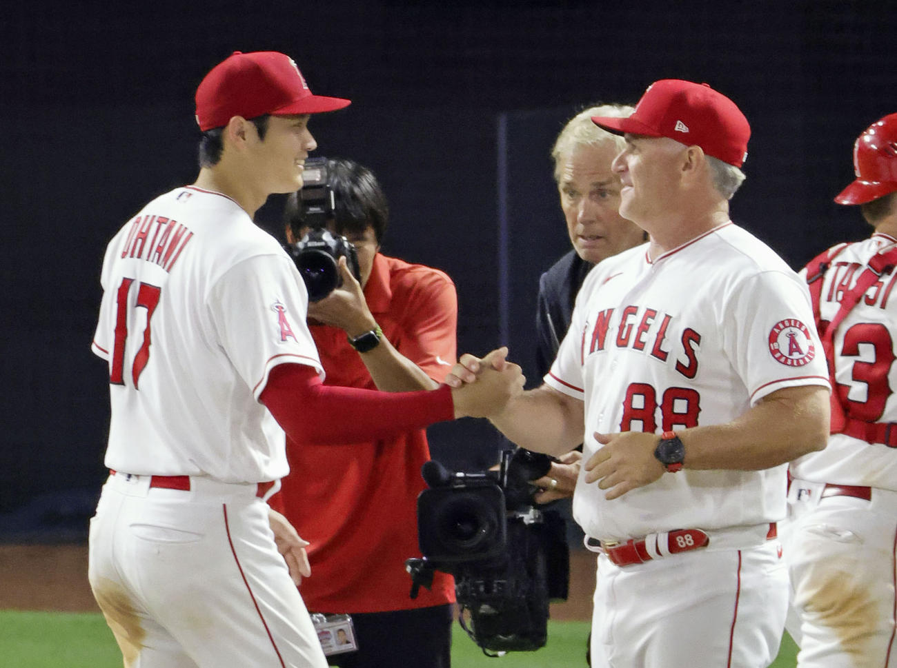 レッドソックスに勝利し、エンゼルスのネビン監督代行（右）に迎えられる大谷（共同）
