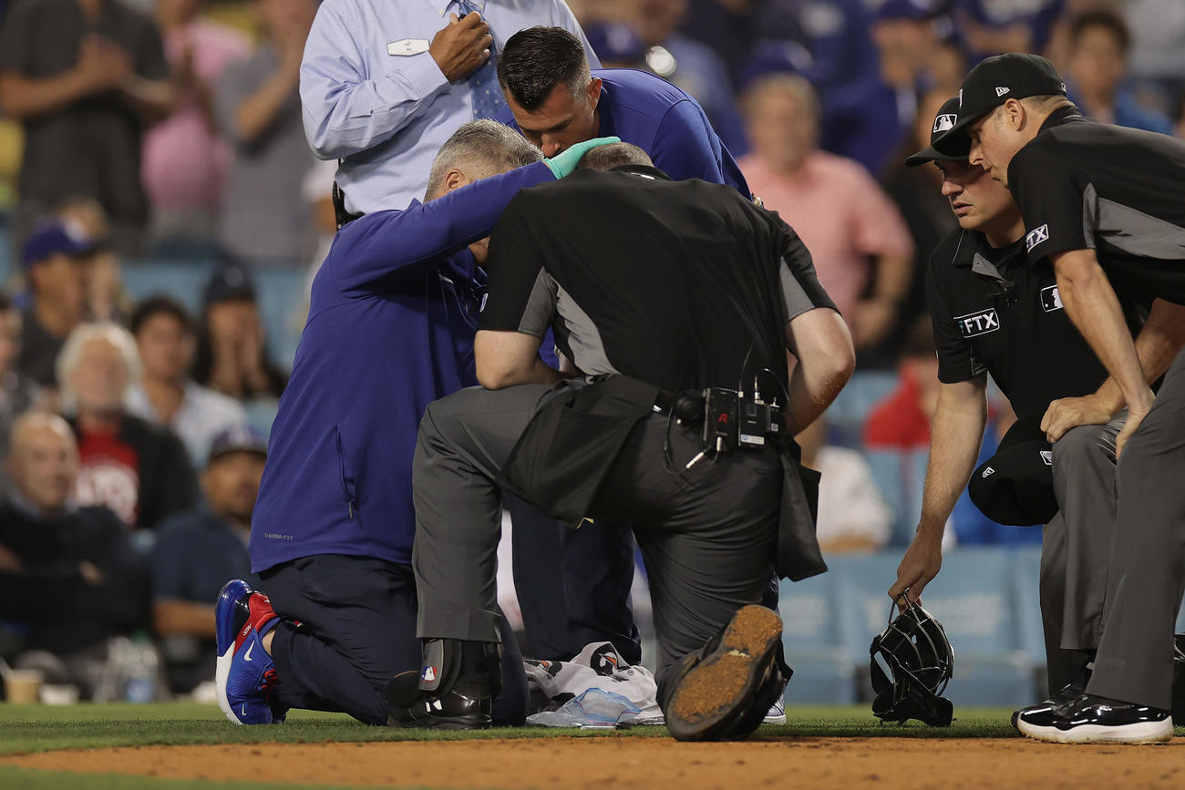 ドジャース対エンゼルス　9回表エンゼルス1死、中前打を放ったトラウトの折れたバットが直撃し、治療を受ける球審（中央）（撮影・前田充）