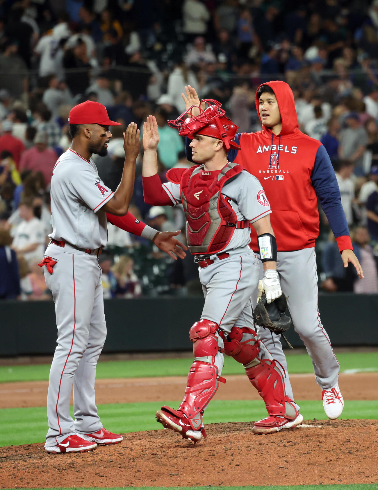 マリナーズ対エンゼルス　延長戦を制し、パーカー姿でチームメートと喜びを分かち合う大谷（右）（撮影・狩俣裕三）