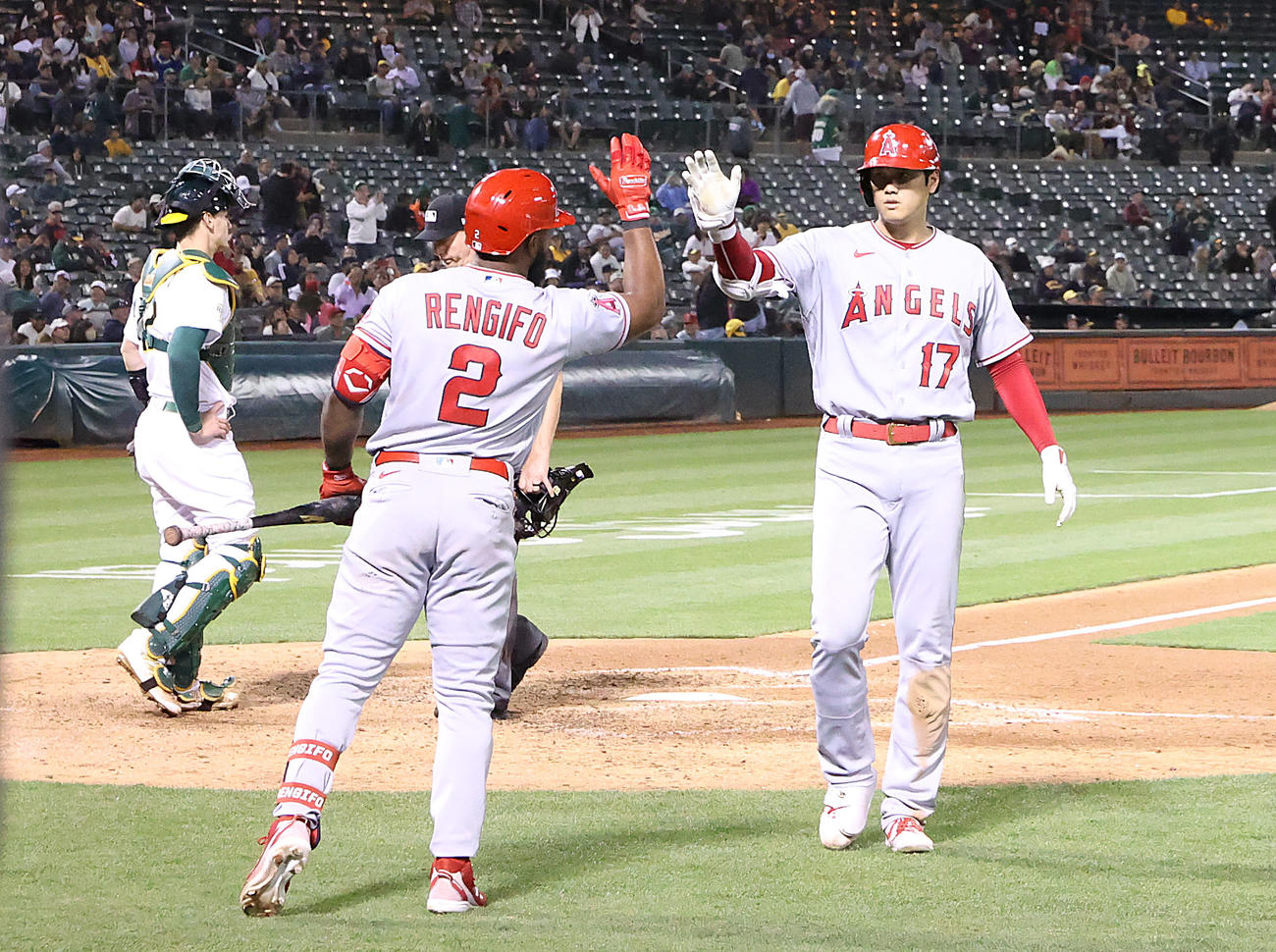 アスレチックス対エンゼルス　7回表エンゼルス無死、ソロ本塁打を放ち、レンフィーフォ（手前）とタッチを交わす大谷（撮影・狩俣裕三）